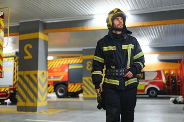 Fototapeta premium Fireman wearing protective uniform standing in fire department at fire station