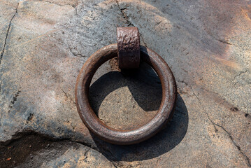 Rusty nautical mooring ring on a island rock