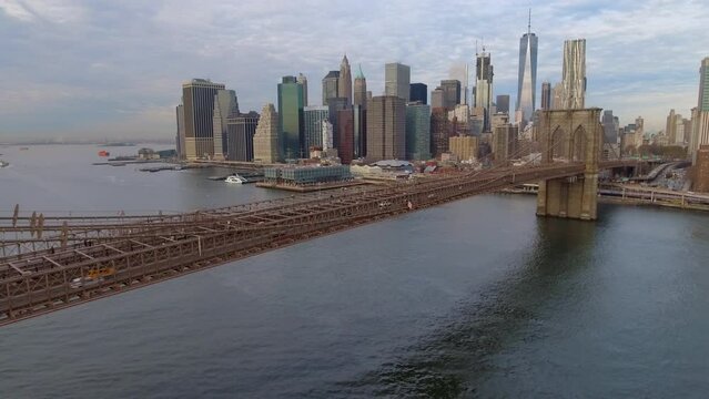 Aerial Shot Of Brooklyn Bridge By Modern Buildings In City, Drone Flying Backwards Over East River - New York, New York