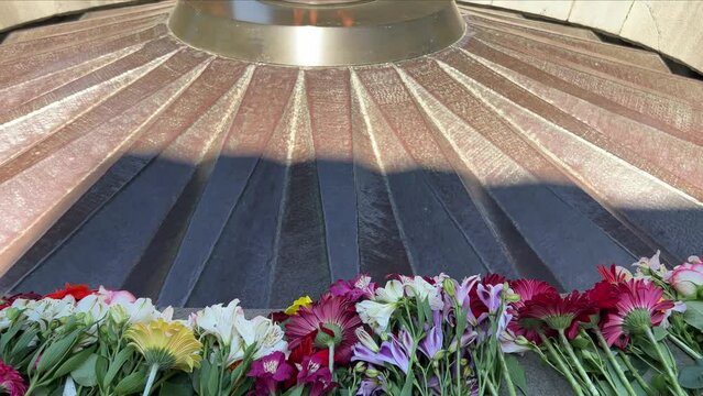 ARMENIA, YEREVAN - MAY 4, 2023: Flowers lie next to eternal fire in the memorial complex of the victims of the Armenian Genocide Memorial complex of 1915 Tsitsernakaberd