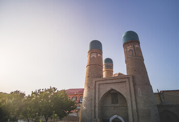 Fototapeta premium Exterior of Chor Minor Madrasah in the ancient city of Bukhara in Uzbekistan, oriental architecture at sunset in the evening