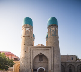 Fototapeta na wymiar Exterior of Chor Minor Madrasah in the ancient city of Bukhara in Uzbekistan, oriental architecture at sunset in the evening