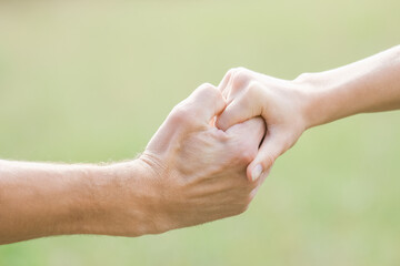 Hands of a happy couple in love outdoors in the summer park