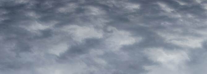 The dark stormy sky is covered with dense gray clouds