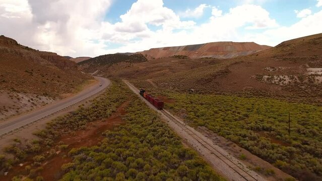 Aerial: Drone Backward Scenic Shot Of Railway Moving On Railroad Track In Semi Arid Tranquil Desert - Ely, Nevada