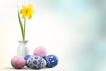 Easter eggs and yellow flower on blur background.