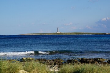 A lighthouse on a landmark in the mediterranean ocean of Menorca