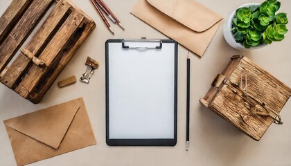 clipboard tablet pad with blank paper sheet on beige table artist home office desk workspace with wooden casket pencil envelopes and stationery flat lay top view mockup with empty copy space