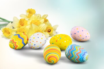 Easter eggs and yellow flower on blur background.