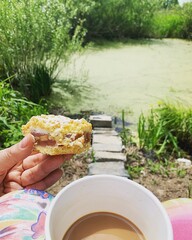 coffee and cake on the bank of the pond, rhubarb cake, coffee in a mug, descending the steps to the pond