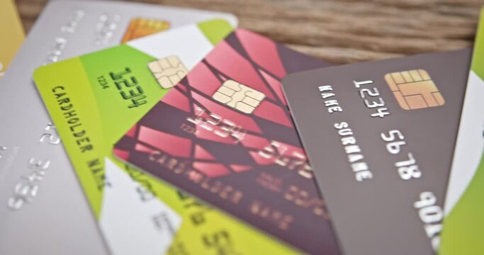 Credit card debt, electronic fund transfer, unsecured consumer debt and personal finance concept : A sweeping panoramic perspective capturing a collection of assorted credit cards gathered in a pile.