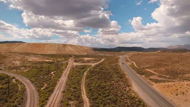 Aerial Forward Shot Of Cars Moving On Road In Semi Arid Desert Area Under Cloudy Sky - Ely, Nevada