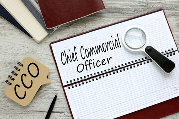 wooden table with diary with text COO Chief Commercial Officer