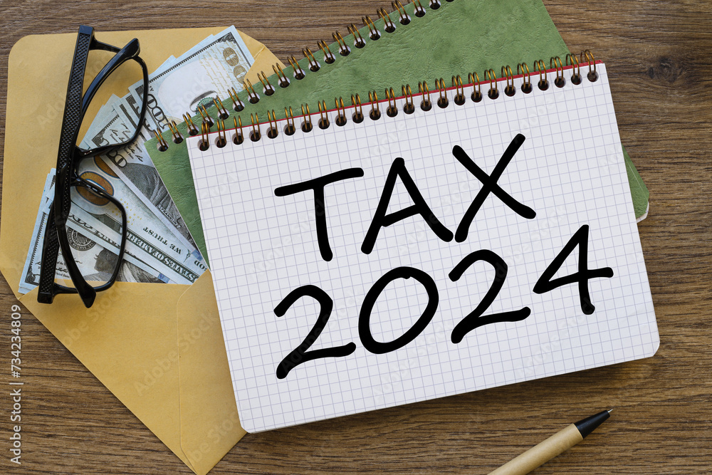 Poster the new year 2024 tax concept. envelope with banknotes under a green notepad. text on the notepad