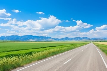 Fototapeta premium A serene motorway surrounded by majestic mountains in the vibrant glow of a sunny day