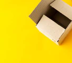 open cardboard box on yellow background, top view