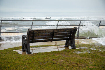 bench during a storm looking over to the beach