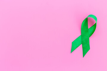 Green ribbon symbol of why cancer and mental health awareness concept