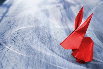 Red rabbit paper origami on colored background