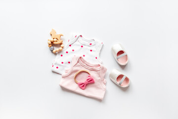 Obraz na płótnie Canvas Flat lay of pink baby clothing and accessories. Kids bodysuit and shoes flat lay