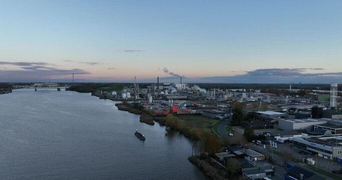 Factory specializing in synthetic polymers and plastics, birds eye aerial drone view in Dordrecht, The Netherlands. Dusk.