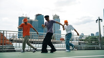 Group of skilled break dancer perform hip hop foot step together at rooftop with city or skyscraper...