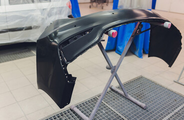 Auto mechanic preparing the car for paint job by applying polish with the power buffer machine