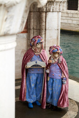 Fototapeta na wymiar Venice, Italy - February 2022 - carnival masks are photographed with tourists in San Marco square