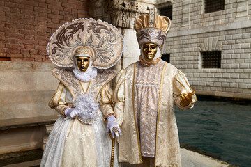 Venice, Italy - February 2022 - carnival masks are photographed with tourists in San Marco square