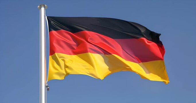 german flag waving on a flagpole with blue sky background