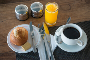 Desayuno con café, zumo de naranja y pan con mantequilla
