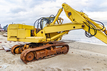 Detail of an old and rusty excavator abandoned on the beach