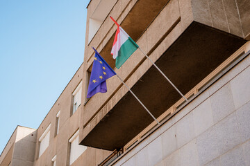 Flag of Hungary and the European Union. European Union and Hungarian flag on the balcony.