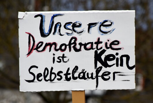 Schild auf einer Demo: "Unsere Demokratie ist kein Selbstl&auml;ufer"