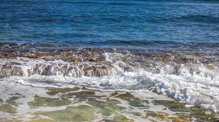 Caribbean sea ocean crashing against the island shore tropical tropics, with pristine blue turquoise water 