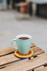 Cup of black coffee on a table in a street cafe.