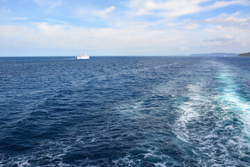 Obraz premium Industrial ships sail on the sea blue waves on the blue sea. Natural landscape with sea traffic