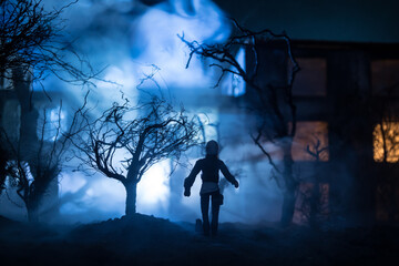 Silhouette of person standing in the dark forest with light. Horror halloween concept.