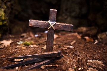 Christian wooden cross and hammer with metal Nails on ground