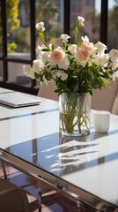Fototapeta na wymiar A close-up of a modern conference table with a glossy white surface and chrome accents. The table is set with laptops, notebooks, and a vase of fresh flowers. The clean lines and minimalist design ex