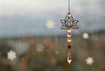 Glass hanging window decoration with glued snowflakes and blurred background