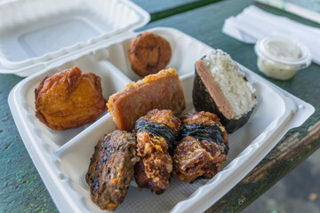 Take-out container with various fried food specialties from a Japanese-style okazuya or Japanese delicatessen in the town of Hilo on the island of Hawaii.