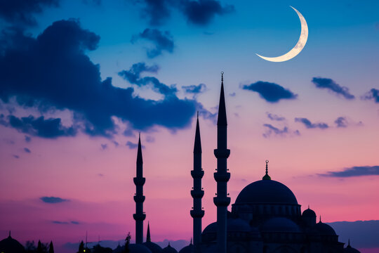 Mosque and crescent moon at twilight.