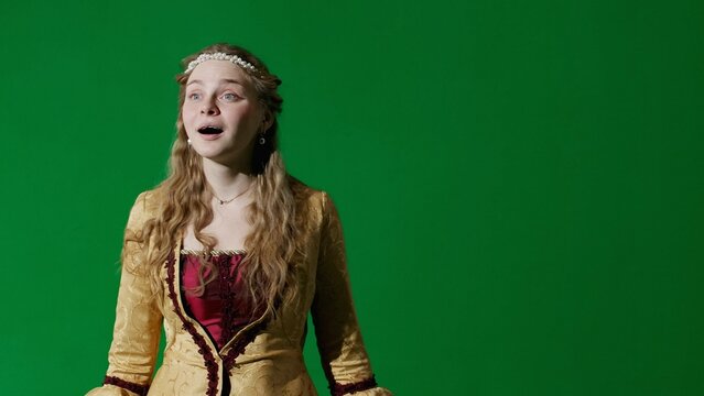 Woman in ancient outfit on the chroma key green screen background. Woman in renaissance style dress looking around with delight. - Powered by Adobe