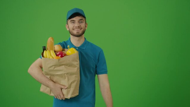 Green Screen Delivery Man Brings Paper Bag with Food. Courier on the Way to Deliver Order to a Client. Deliveryman Worker Deliver Online Order Client.