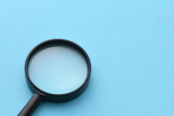 Black magnifier on a blue background.