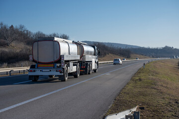 A huge truck with two large trailers is moving on the highway. Transportation of liquid...