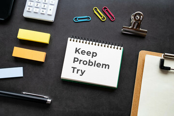 There is notebook with the word Keep Problem Try. It is as an eye-catching image.
