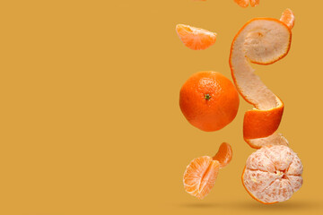 Flying tangerines on orange background with space for text
