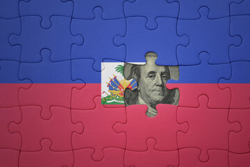 puzzle with the national flag of haiti and usa dollar banknote. finance concept